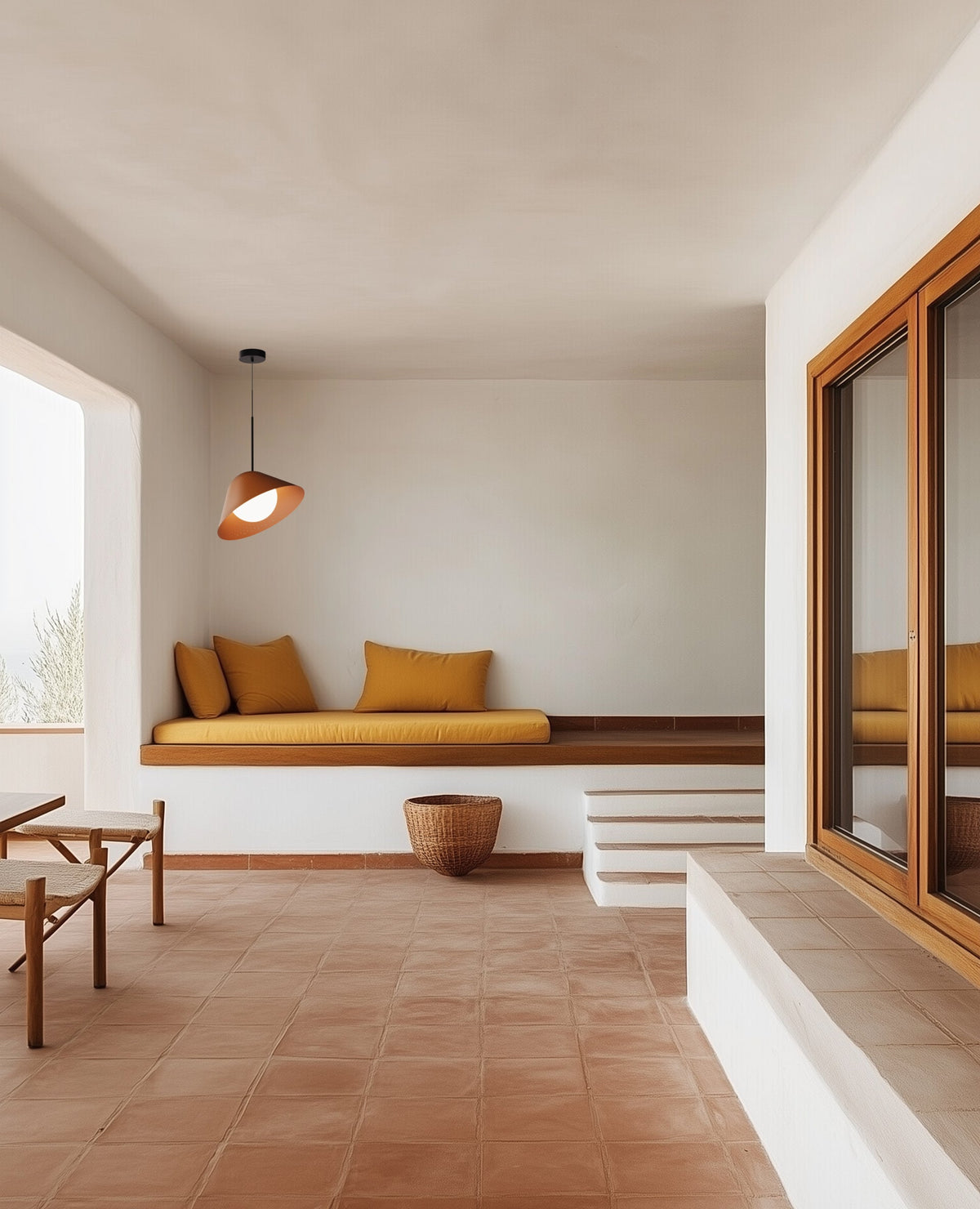 Bola Bell perforated metal pendant tilted over a lounge seating area