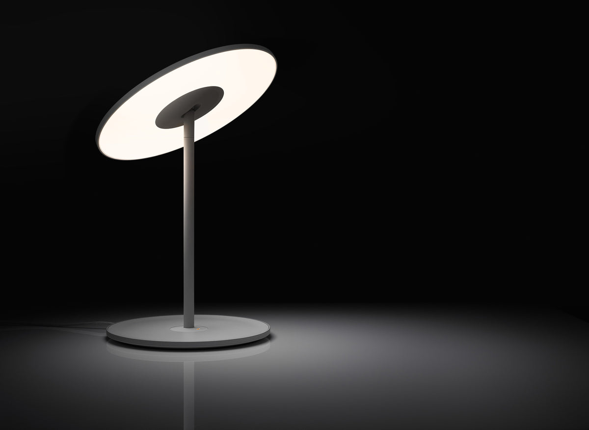 Circa white disc lamp, lit close-up of the flat LED face