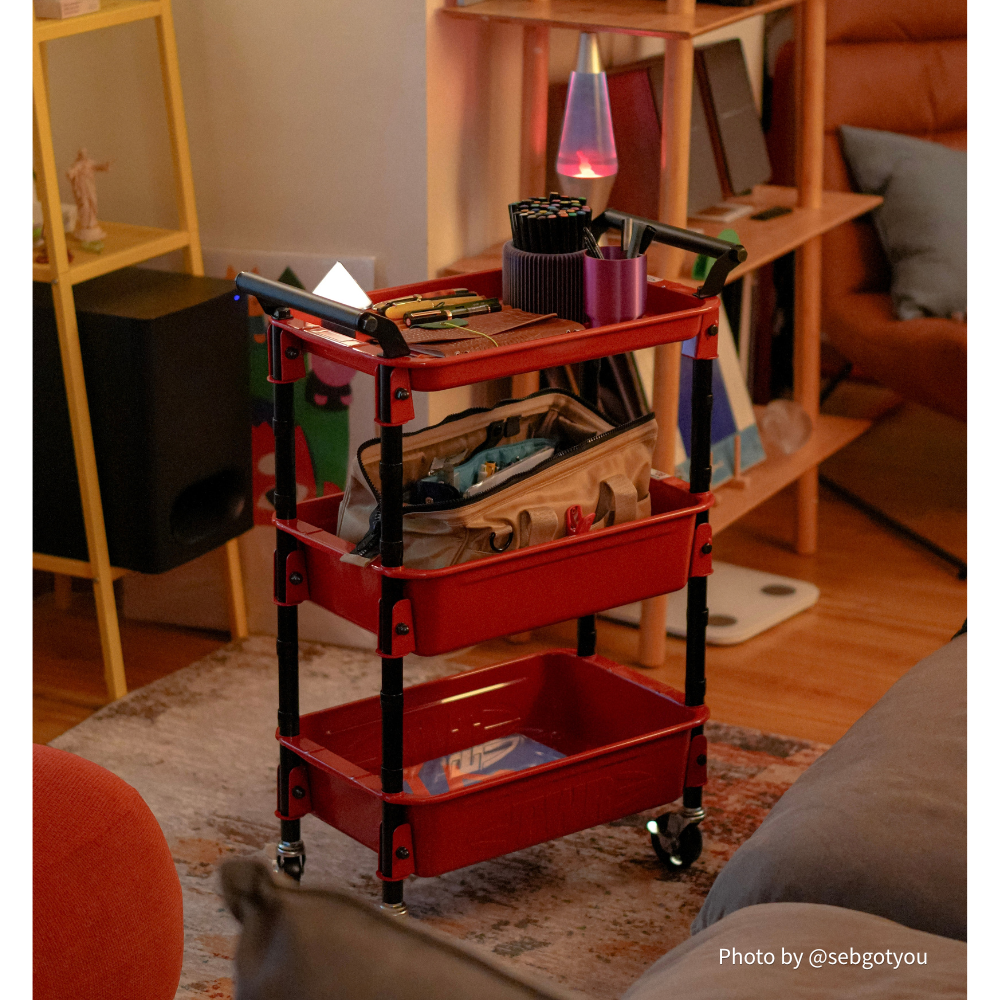 Toyo Steel TWR-4 Three-Tier Rolling Steel Cart – Red, beside a studio sofa