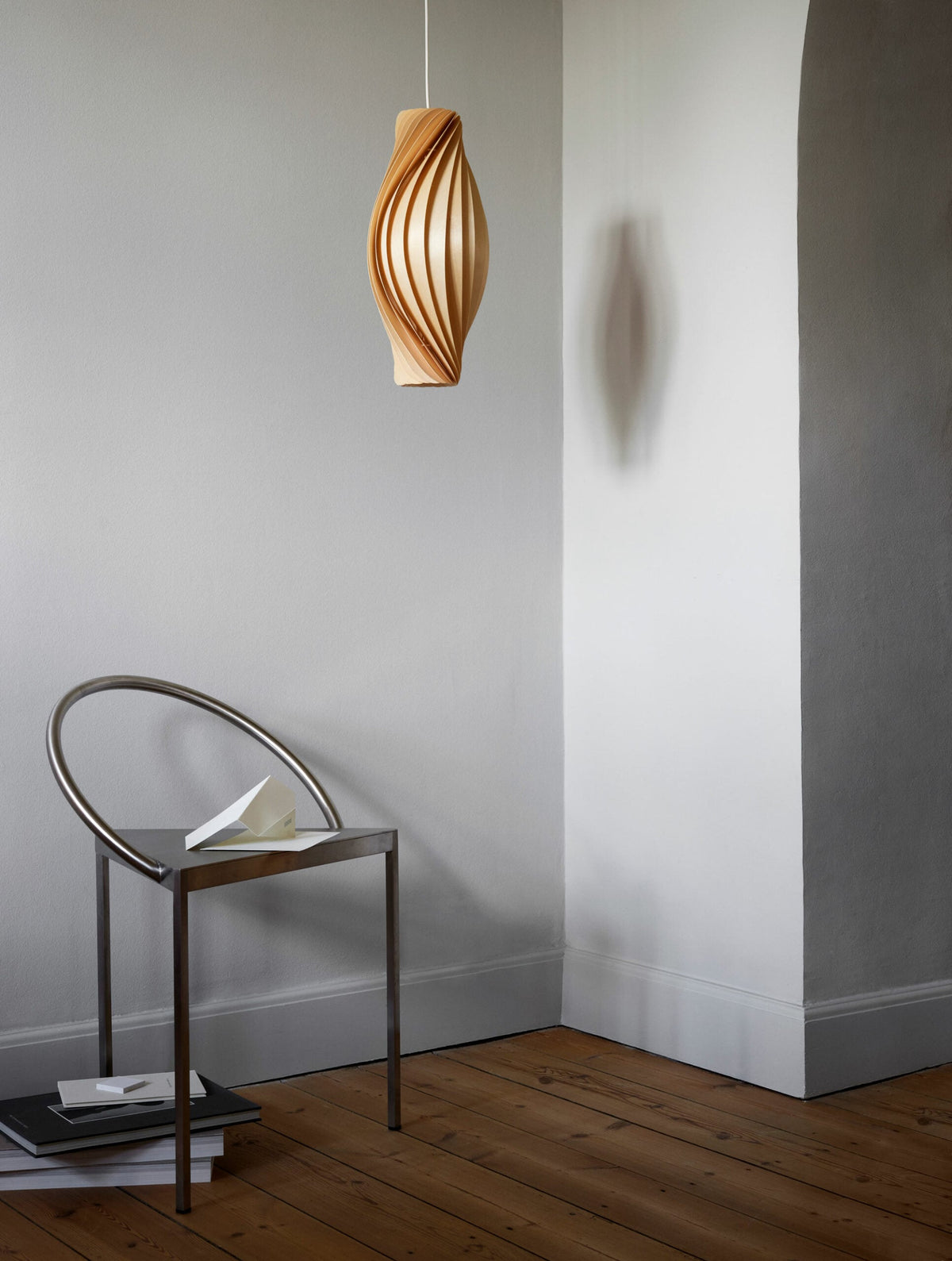 Tom Rossau No.111 pendant light – in a corner by a chair, unlit