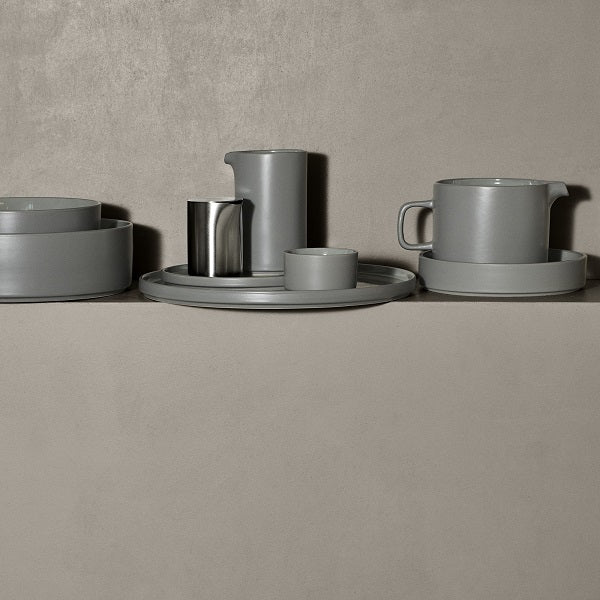 blomus PILAR Stoneware Pitchers, 17 oz or 34 oz – Pewter pitchers with cups on a stone ledge