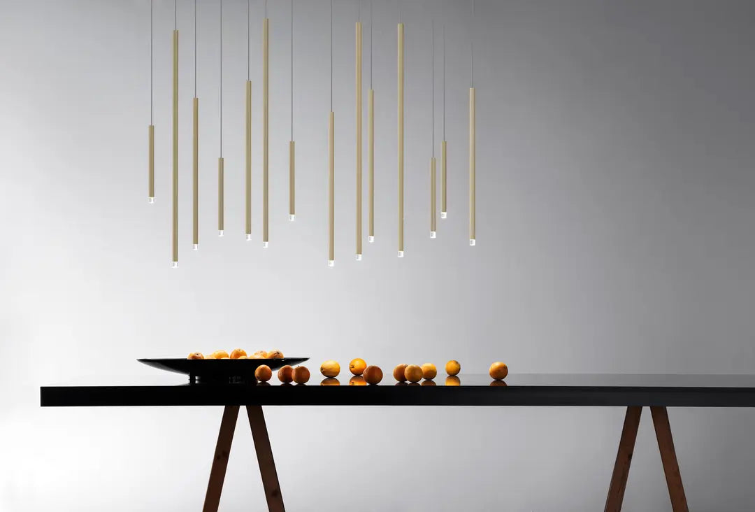 Gold finish Lodes A-Tube Nano designer pendant light installed over large dining table