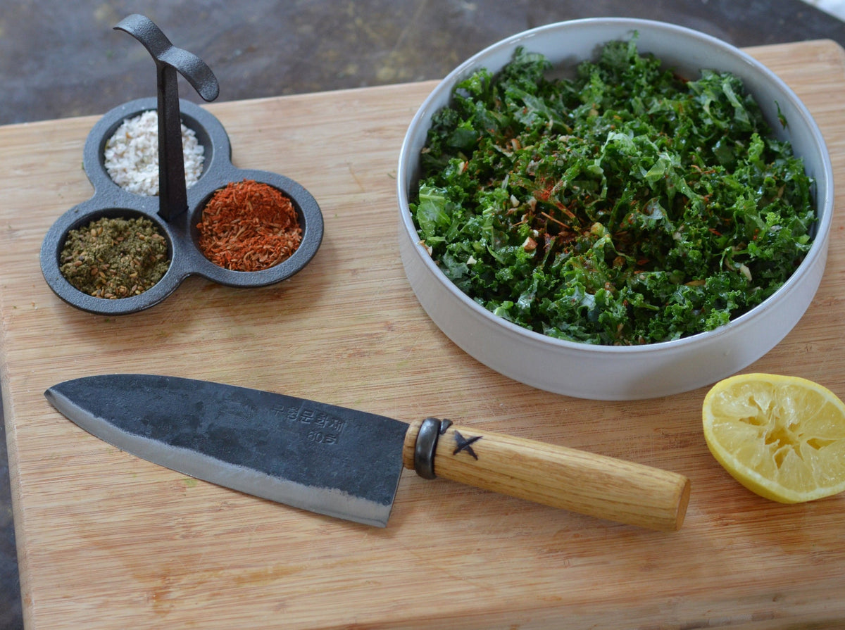 #62 kitchen knife with a bowl of fresh herb sauce