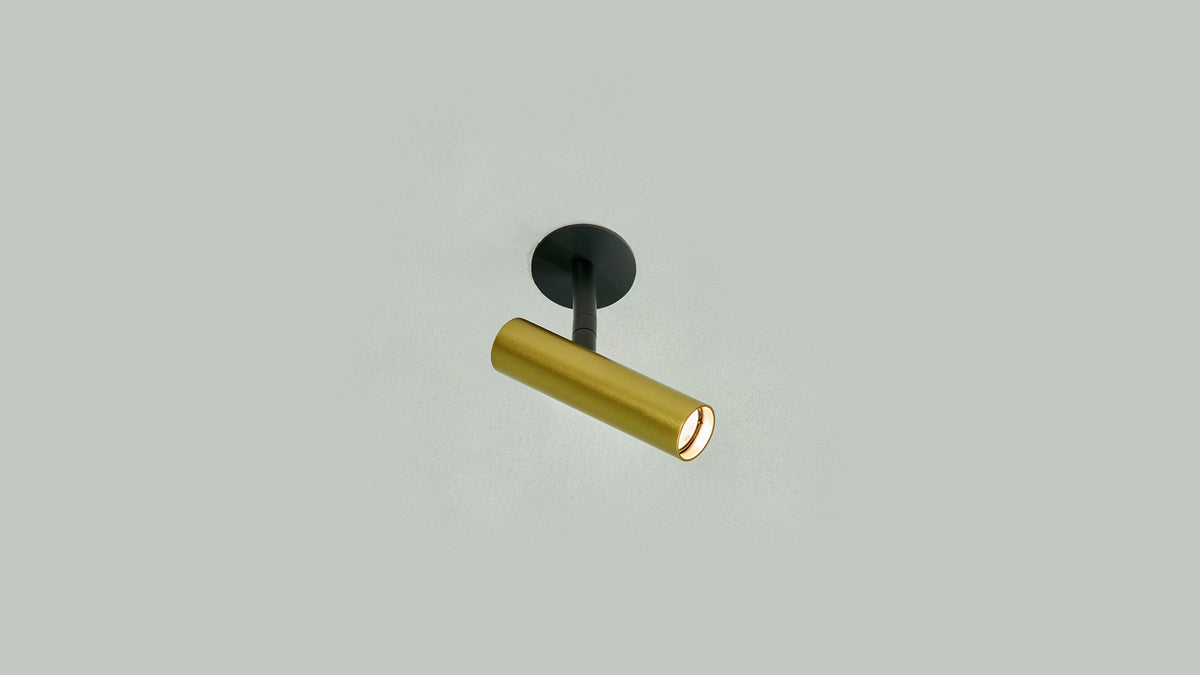 Gold Anvil Slim Spot recessed spotlight angled on a pale grey ceiling