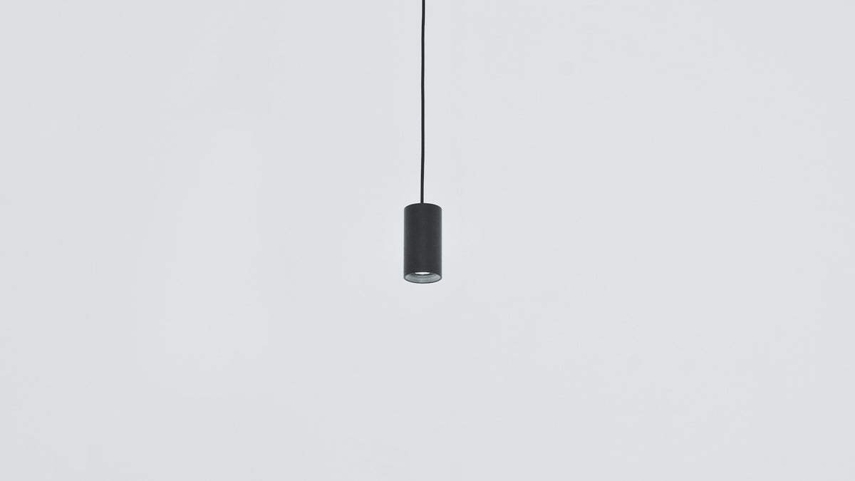 Black Anvil Spot S spot pendant hanging against a pale wall