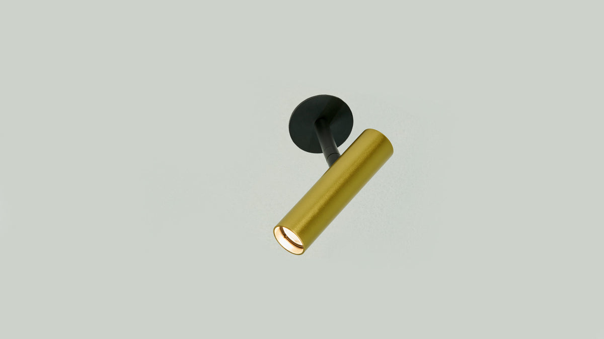 Gold Anvil Slim Spot recessed spotlight pointing down from a black trim