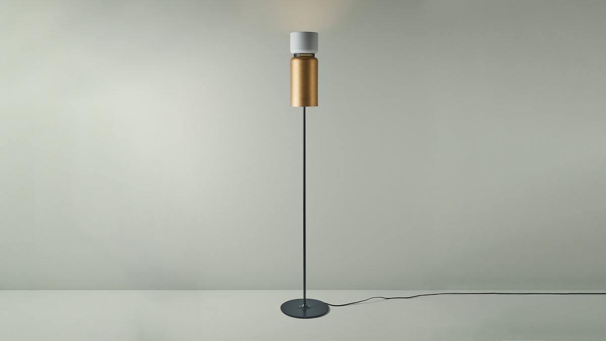 B.lux Aspen floor lamp with a white top shade and brass bottom shade, studio view