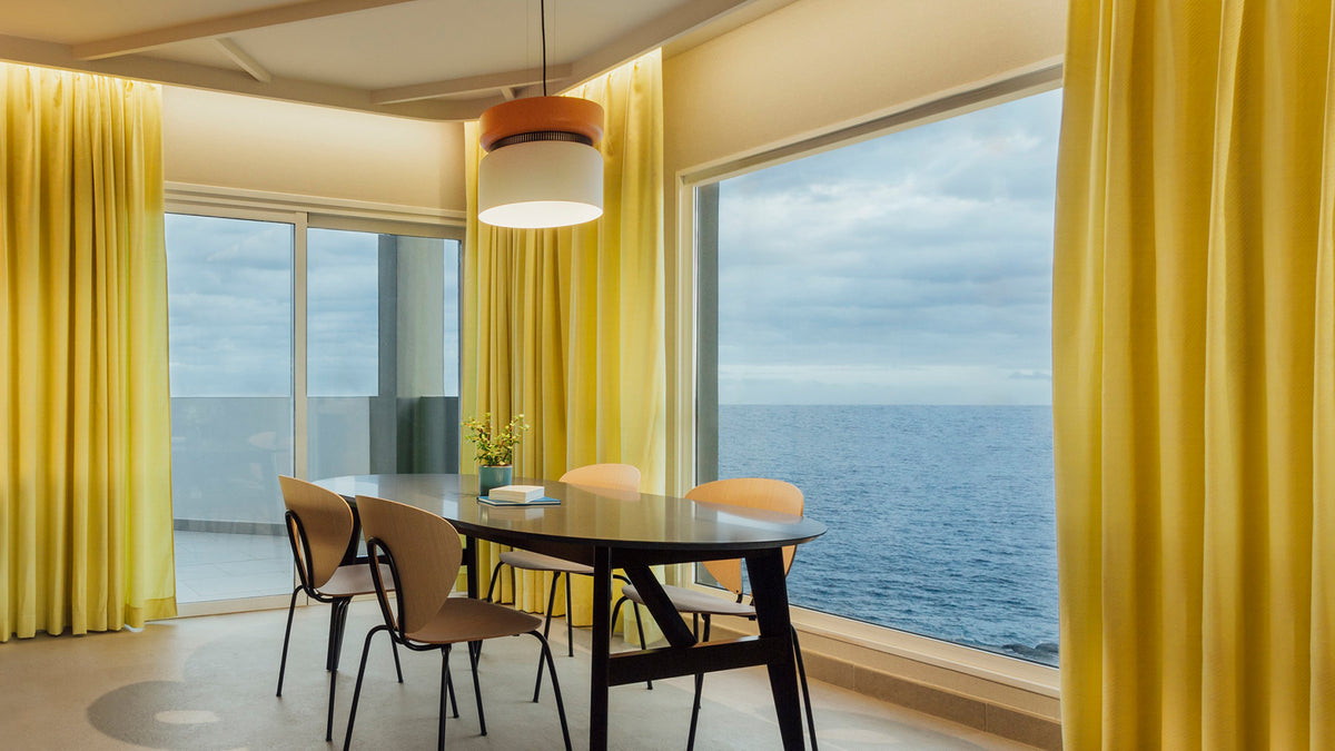 B.lux Aspen pendant over a dining table in a room with sea-view windows