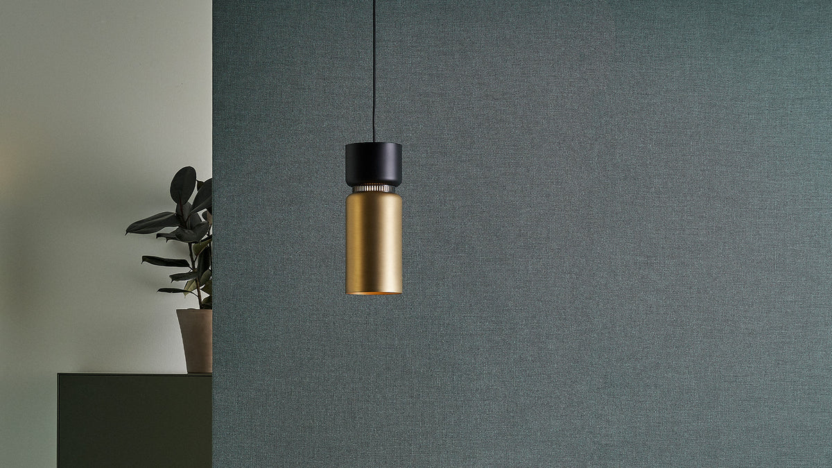 B.lux Aspen S pendant, brass bottom shade with a black top, in a room corner