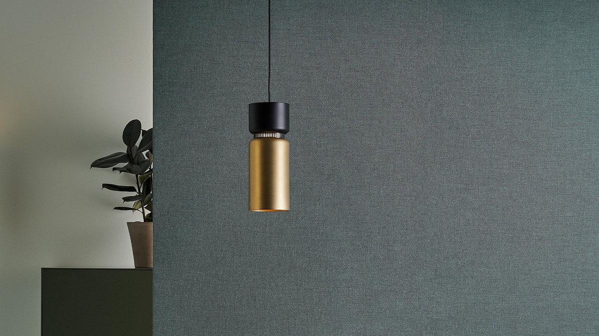 B.lux Aspen S pendant, brass bottom shade with a black top, in a room corner