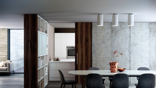 Three white Aspen C ceiling lamps over a dining table in a kitchen