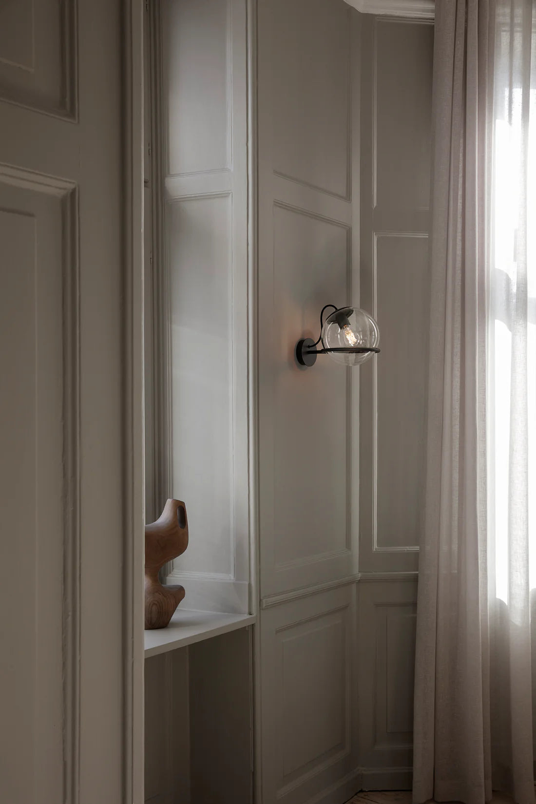 Astep 237/1 wall sconce shown for scale, highlighting its compact 14cm clear glass sphere design.