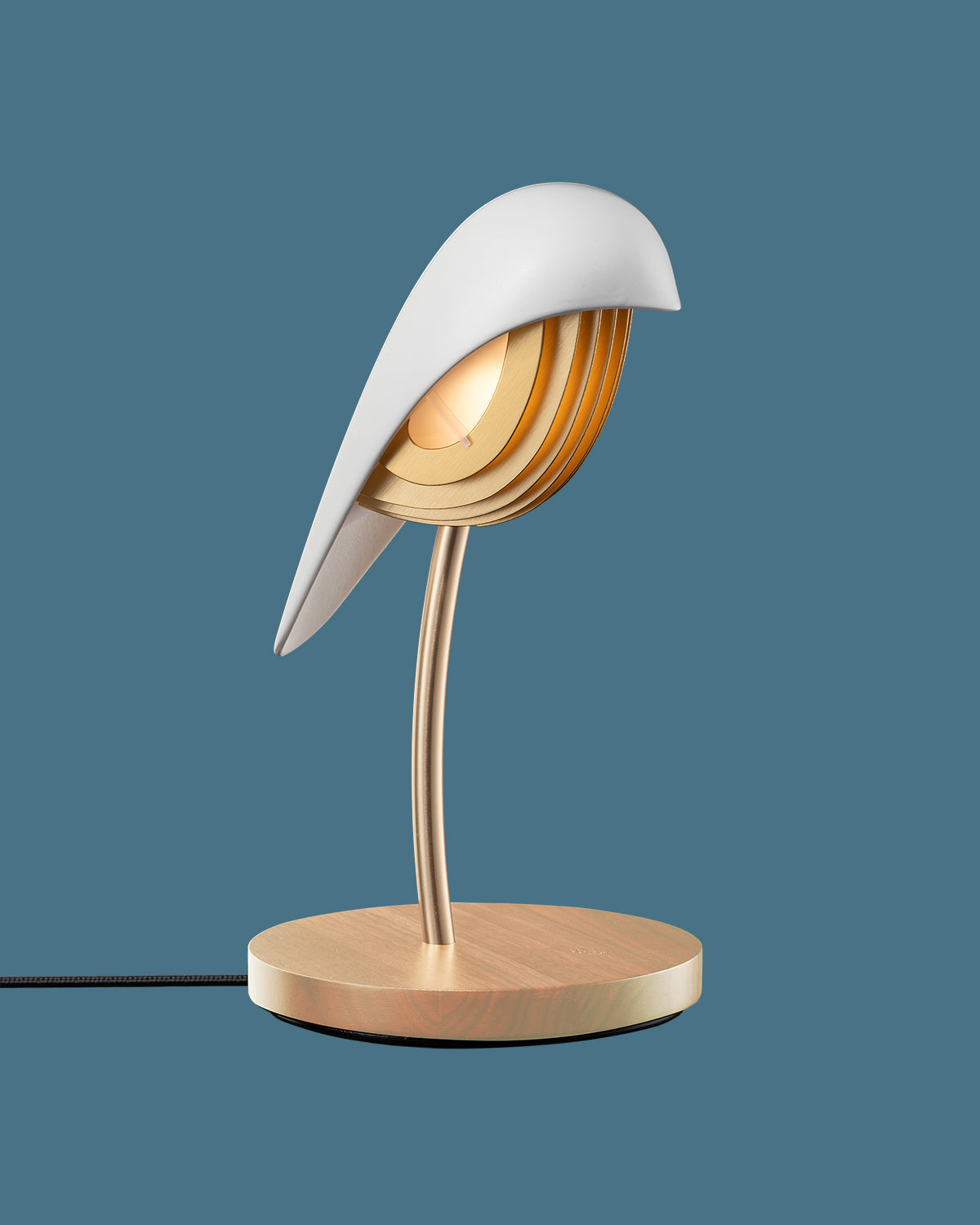Daqiconcept Bird Ivory White desk lamp against a blue backdrop, side view