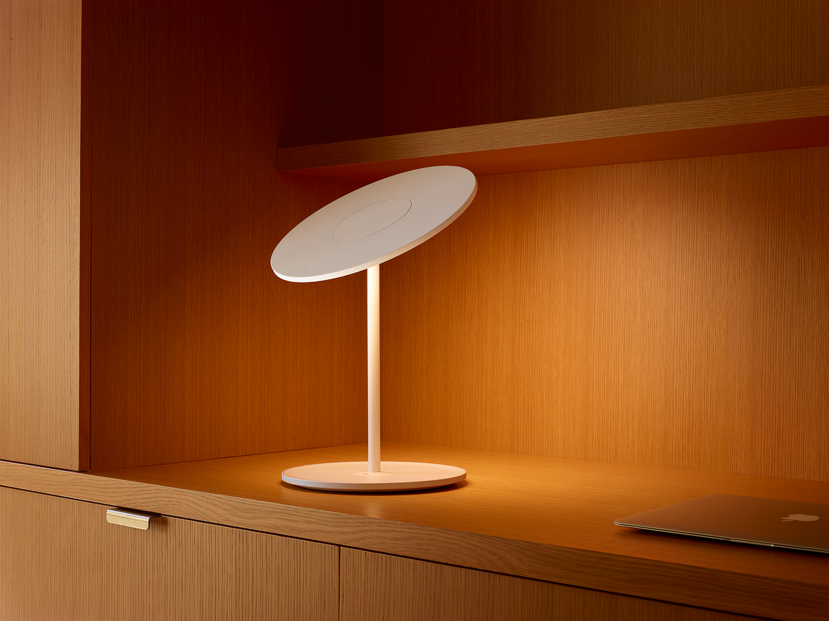 Circa tilting disc lamp lighting a work surface at night