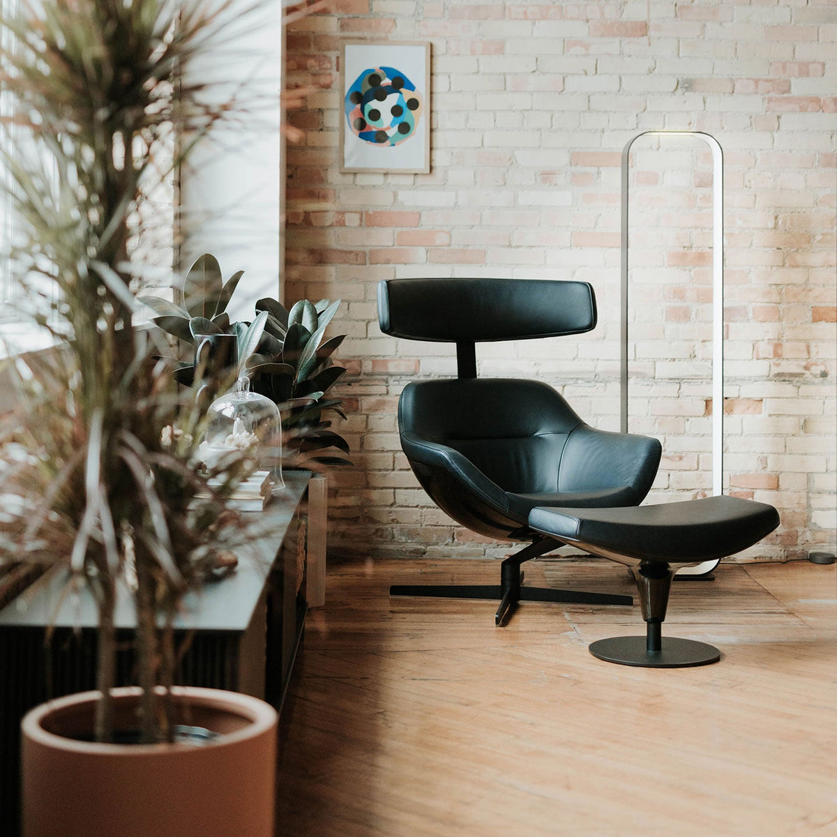 Contour open-frame floor lamp glowing in an office lounge setting