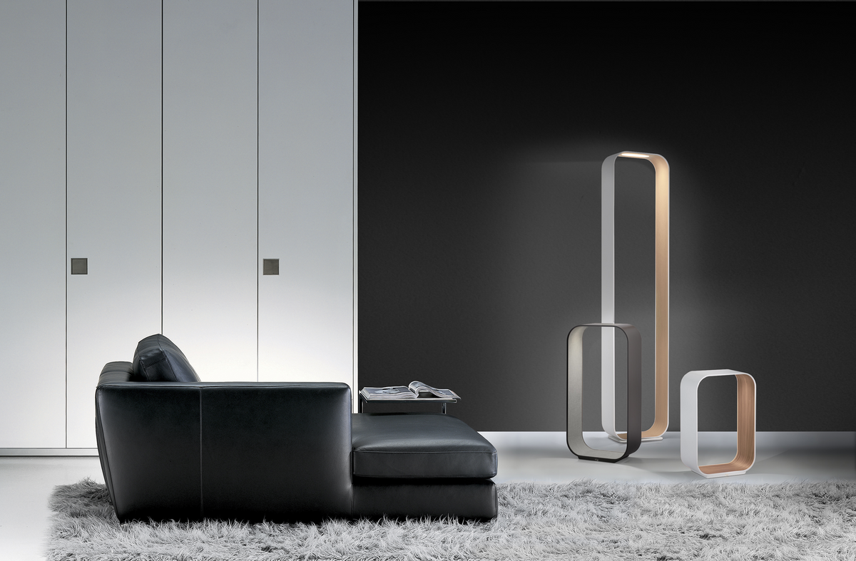 Contour floor lamp with wood interior lit beside a sofa, view 4