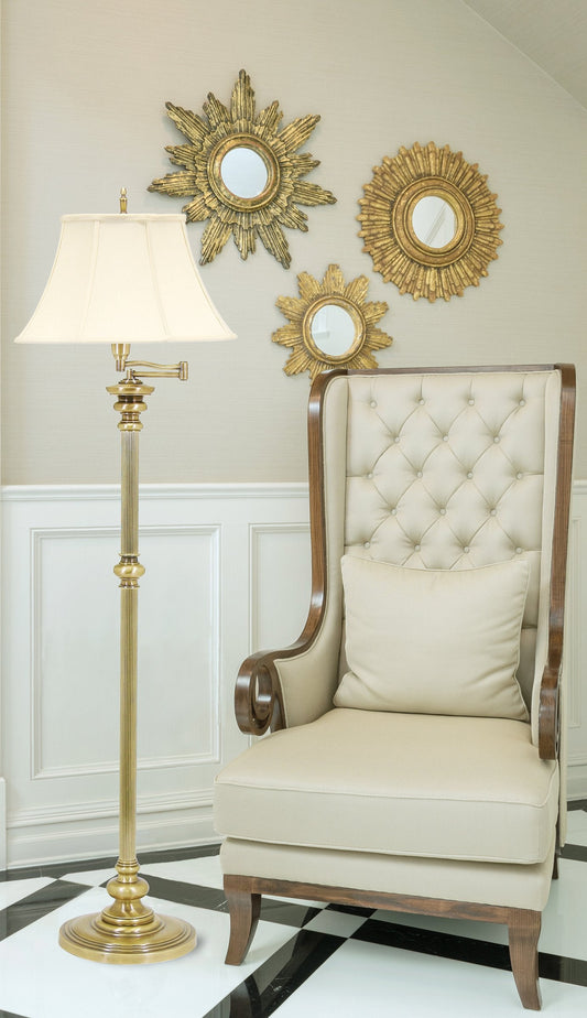 House of Troy Newport 61" Swing Arm Floor Lamp in Antique Brass in a room setting