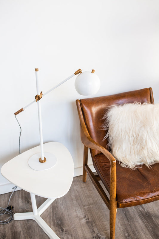 House of Troy Orwell LED Counterbalance Table Lamp in White with Weathered Brass Accents in a room setting