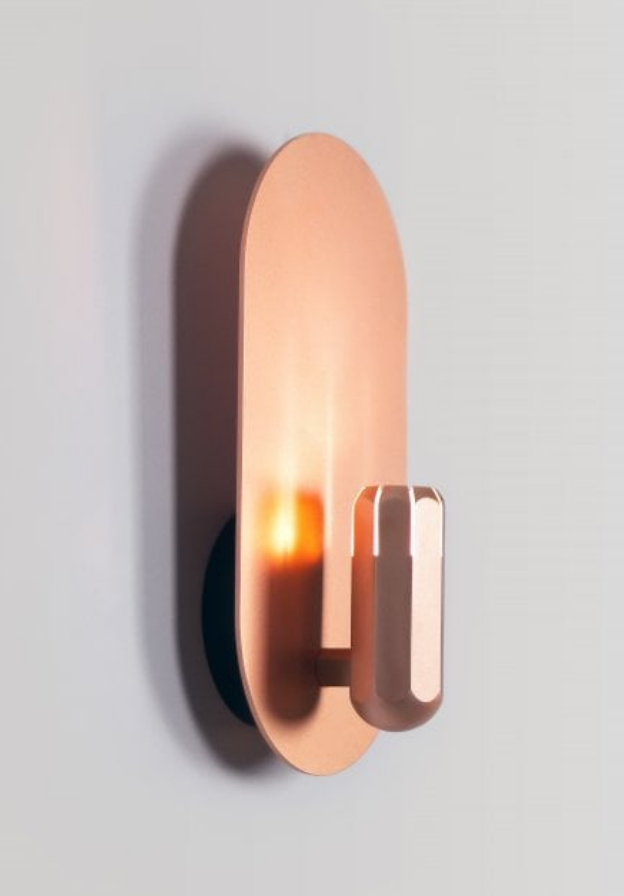 Luxurious copper Innermost Brixton wall fixture, casting indirect light in a contemporary living room space.