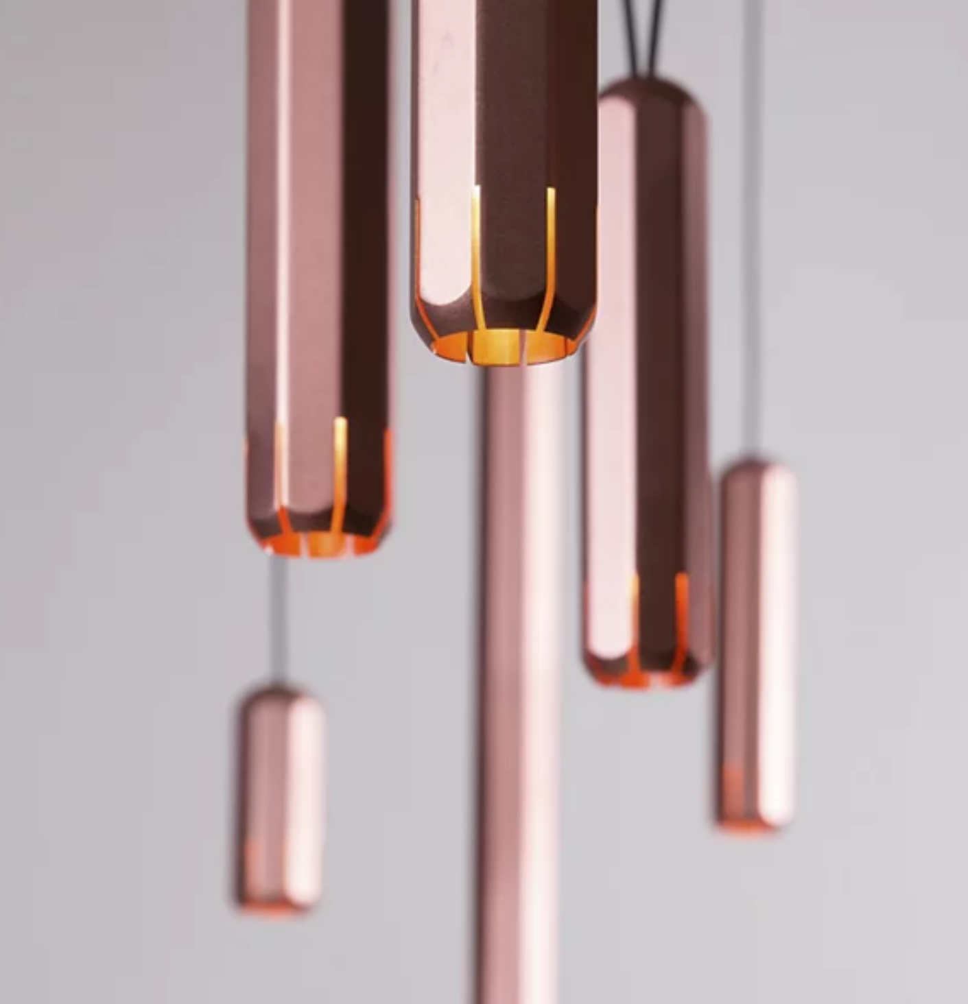 Multiple Innermost Brixton copper aluminum and stainless steel pendant lights installed in a modern open-plan living space.