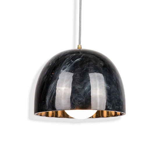 Doric 28 LED pendant light with polished black marble resin shade hanging in a modern living room.