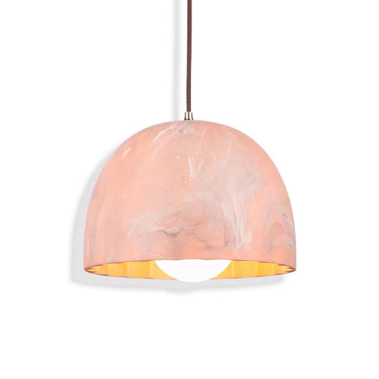 Ambient lighting from Doric 28 rose marble LED fixture, 2700K warm glow creating a cozy atmosphere in a hotel lobby.