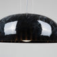 Innermost Doric 60 LED pendant light in polished black marble finish, hanging over a modern dining table.