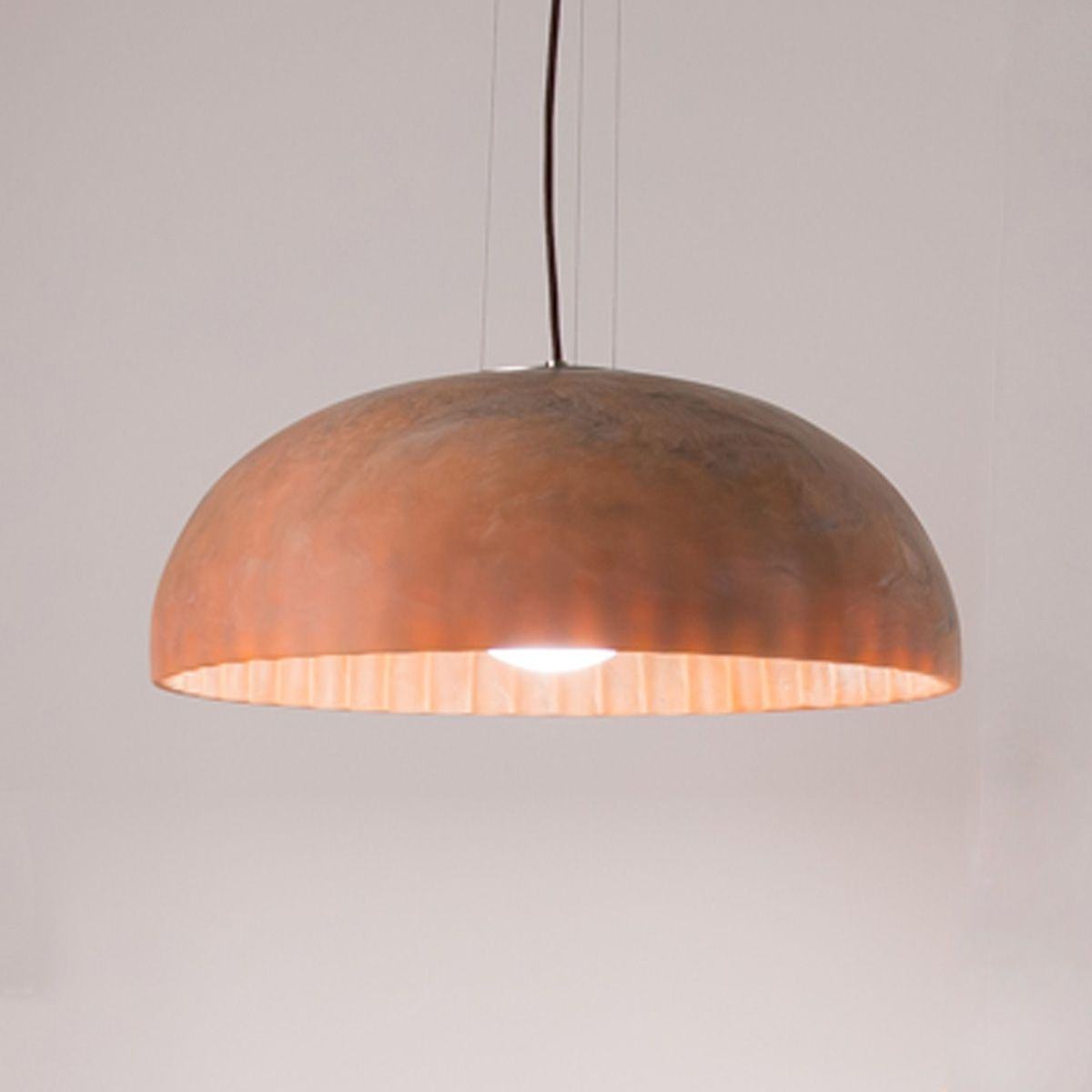 Rose marble Doric 60 LED ceiling light illuminating a minimalist bedroom with soft, diffused glow.