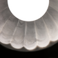 Close-up of Doric 60 pendant light showing translucent resin material and internal scalloped details, ambient warm light.