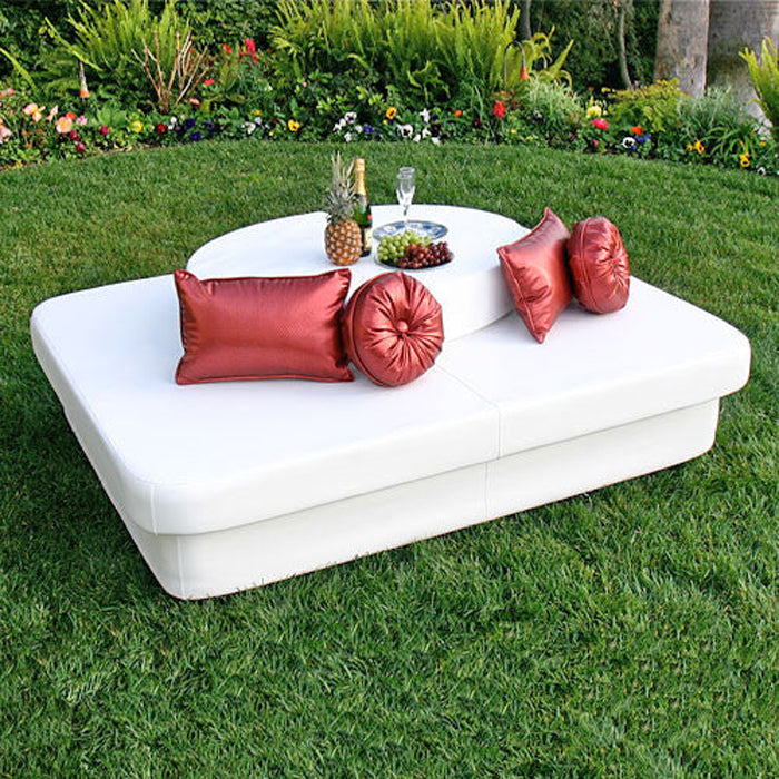 White Crib daybed with red pillows and a tray on a lawn