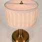 Mini Tito Cordless Table Lamp Dark Antique Brass Pleated Shade beside bed