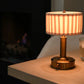 Mini Tito Cordless Table Lamp in dark antique brass with pleated shade in study