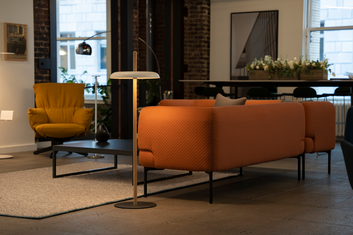 Nivél rechargeable floor lamp glowing warm in a lounge setting