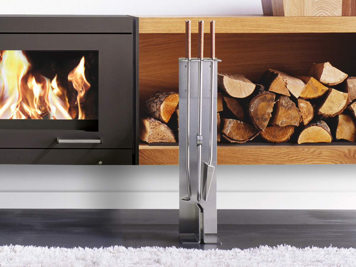 Peter Maly Fireside Tools with Floor Stand by Conmoto – in front of a stacked firewood shelf