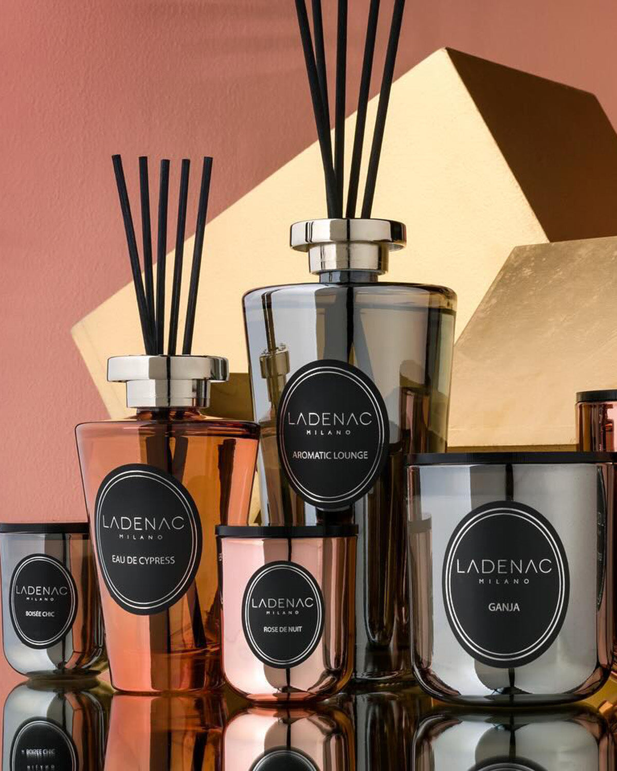Urban Senses deluxe reed diffuser 500 ml by Ladenac Milano, diffusers and candles grouped on a pink and gold backdrop