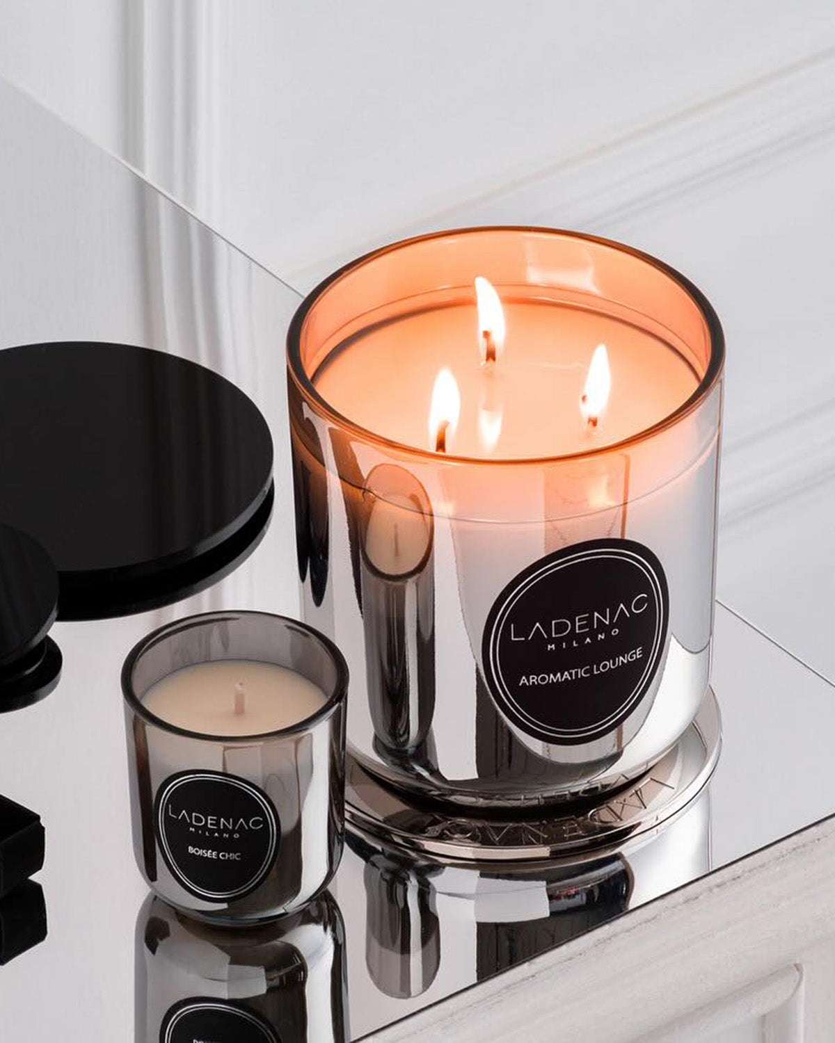 Urban Senses 200 g scented candle by Ladenac Milano, lit gold pink candle on a marble surface