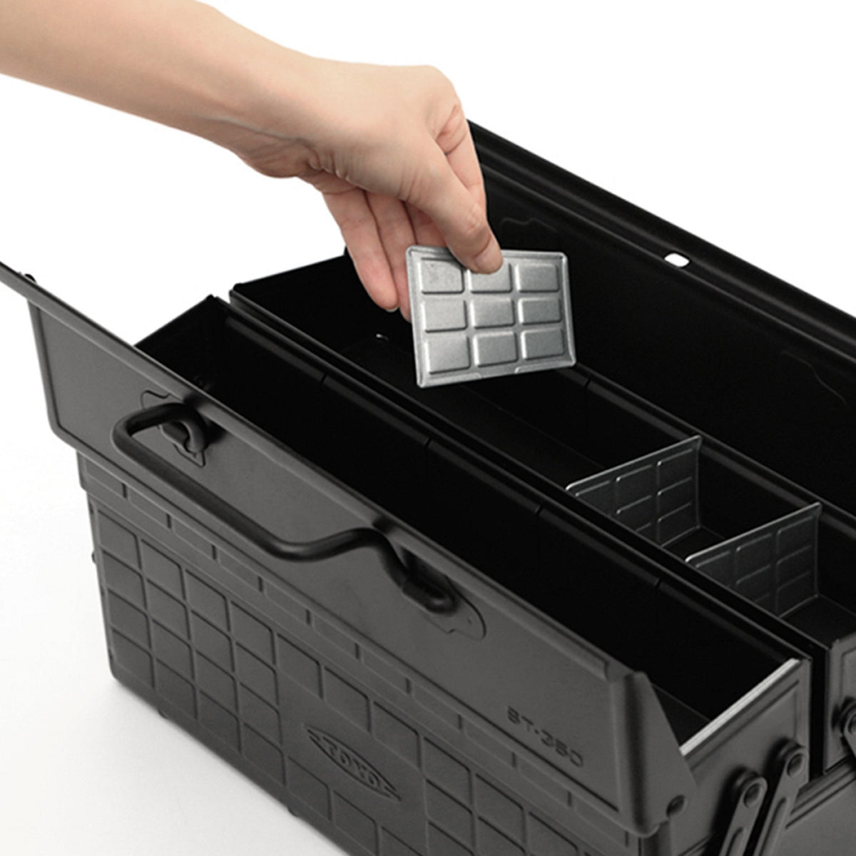 Black ST-350 tray being filled by hand