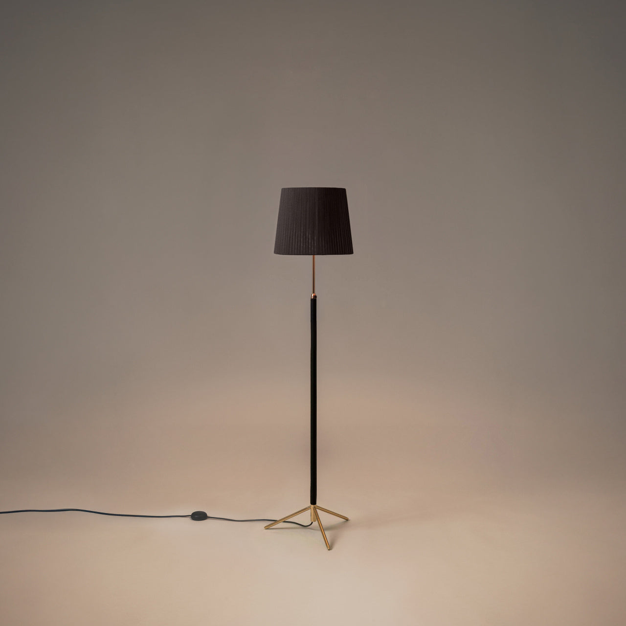 Santa & Cole Pie de Salón G3 designer floor lamp in Black Ribbon with polished brass finish and warm ambient lighting