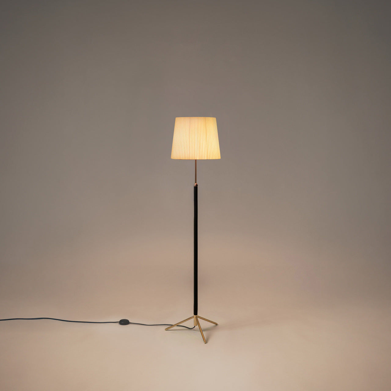 Santa & Cole Pie de Salón G3 designer floor lamp in Natural Ribbon with polished brass finish and soft ambient lighting