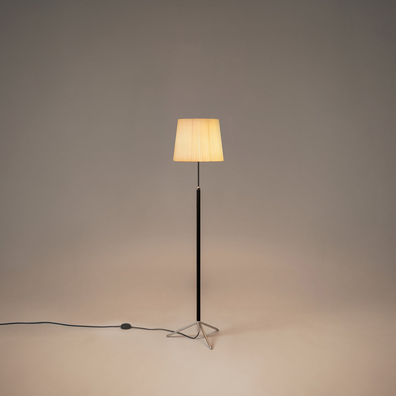 Santa & Cole Pie de Salón G3 floor lamp with Natural Ribbon shade and chrome finish beside a modern lounge chair