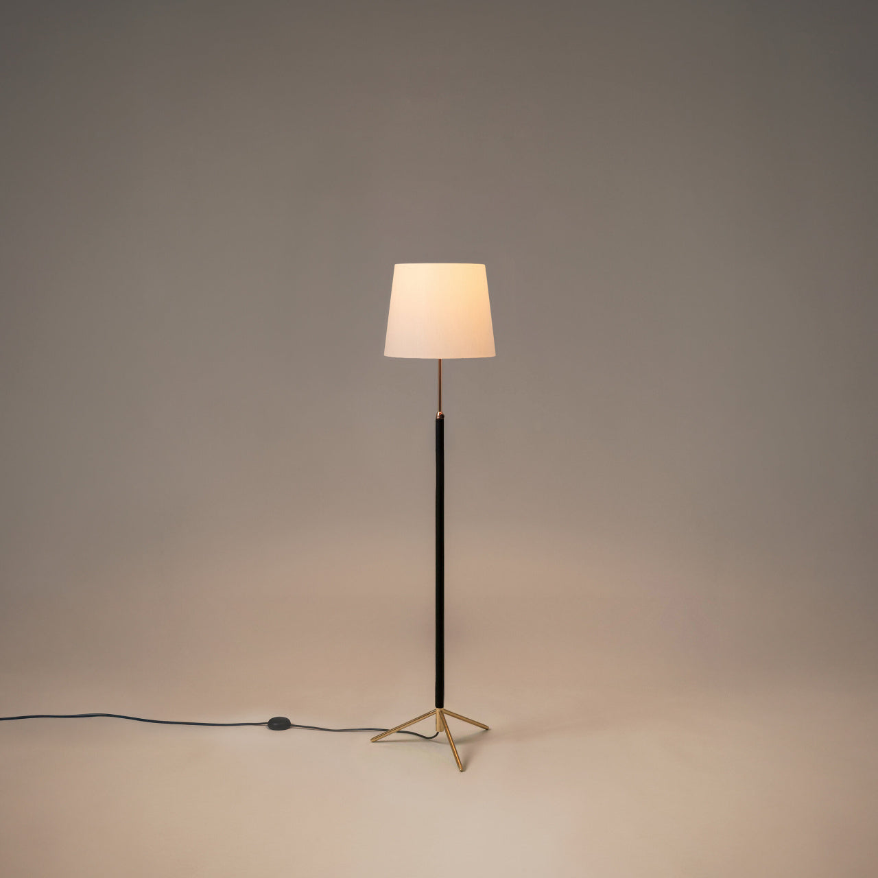 Adjustable Santa & Cole Pie de Salón G3 floor lamp featuring a White Linen shade and polished brass frame