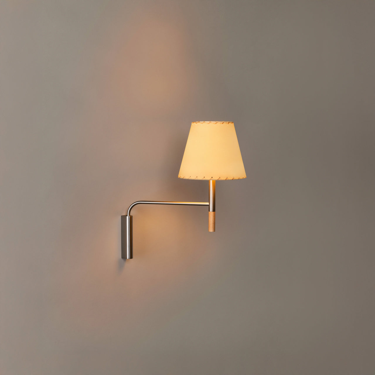 Adjustable wall sconce with stitched beige parchment shade and satin nickel hardware for modern homes
