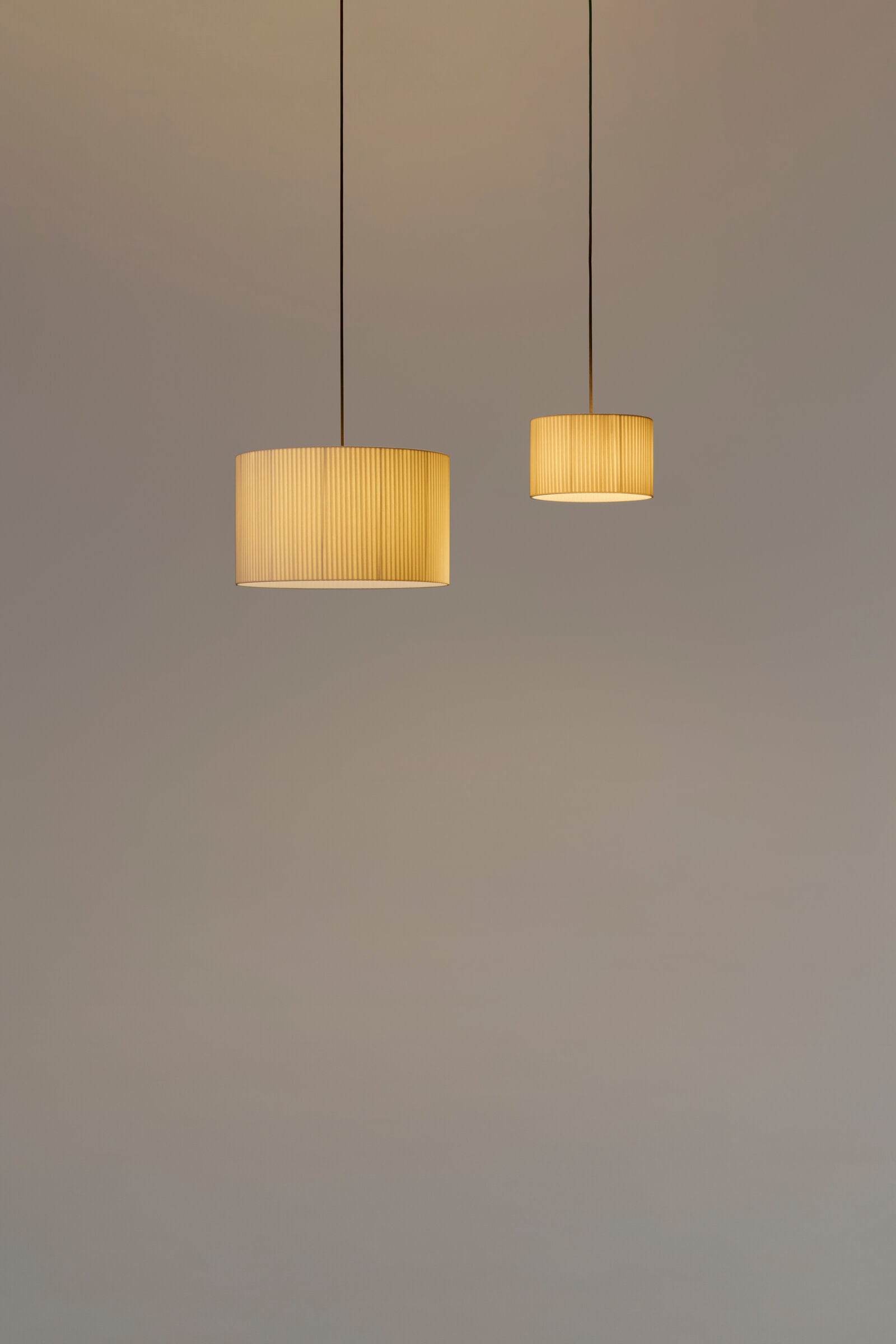 Modern cylindrical pendant light with natural ribbon shade by Santa & Cole for dining rooms