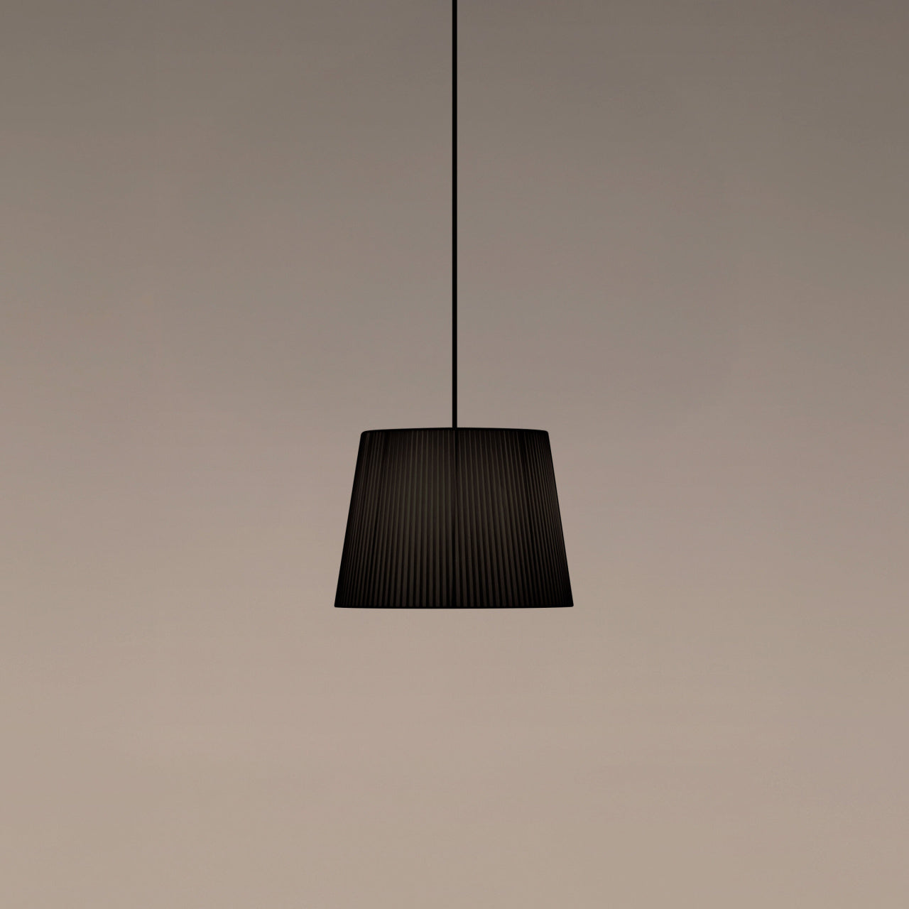 Santa & Cole GT3 pendant light with black ribbon shade creating warm ambient lighting in a modern interior