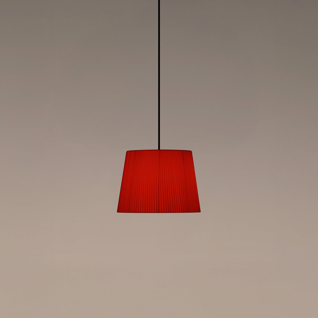 Santa & Cole GT3 pendant light with red-amber ribbon shade creating warm ambient lighting in a contemporary interior