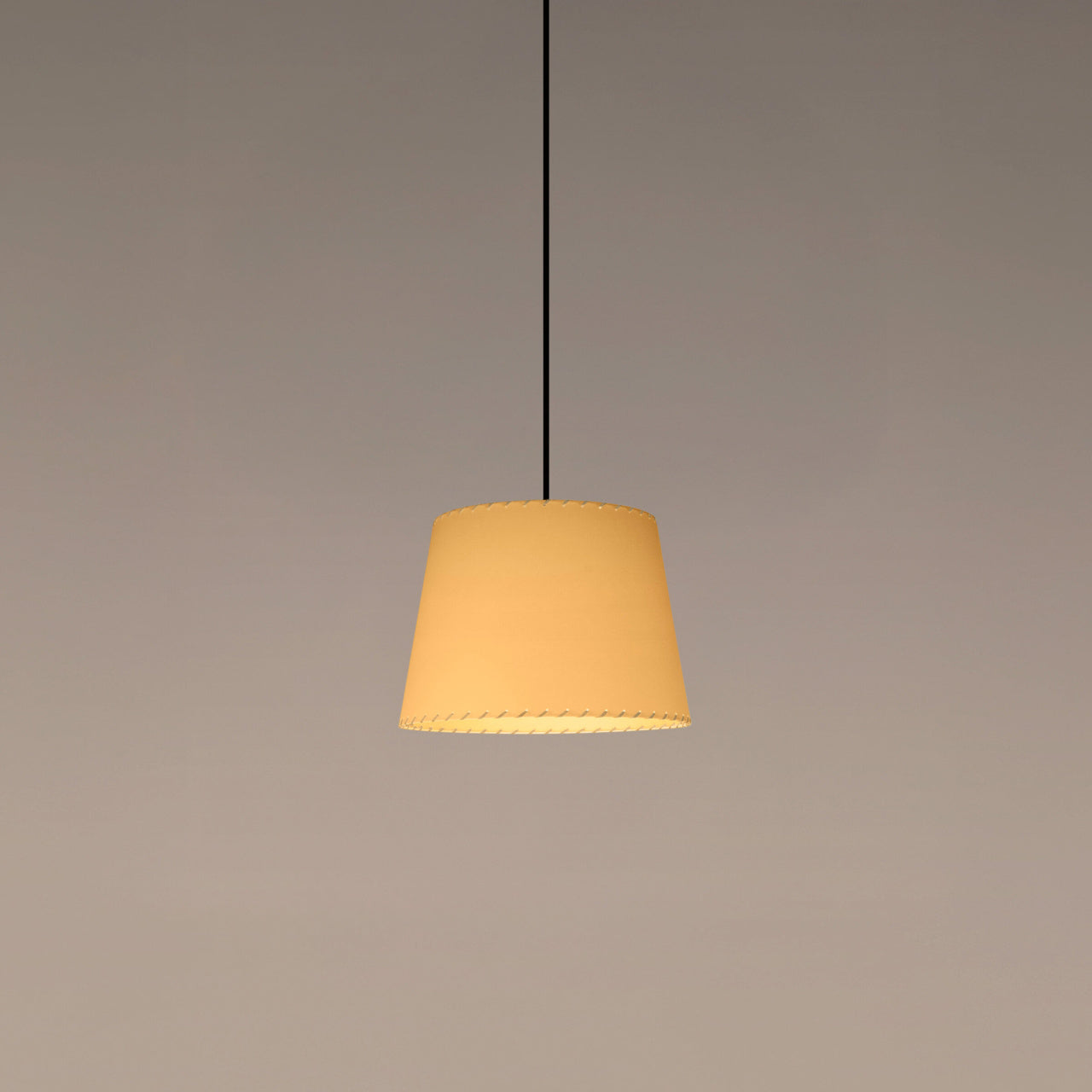 Santa & Cole GT3 pendant light with stitched beige parchment shade creating warm ambient lighting in a contemporary interior