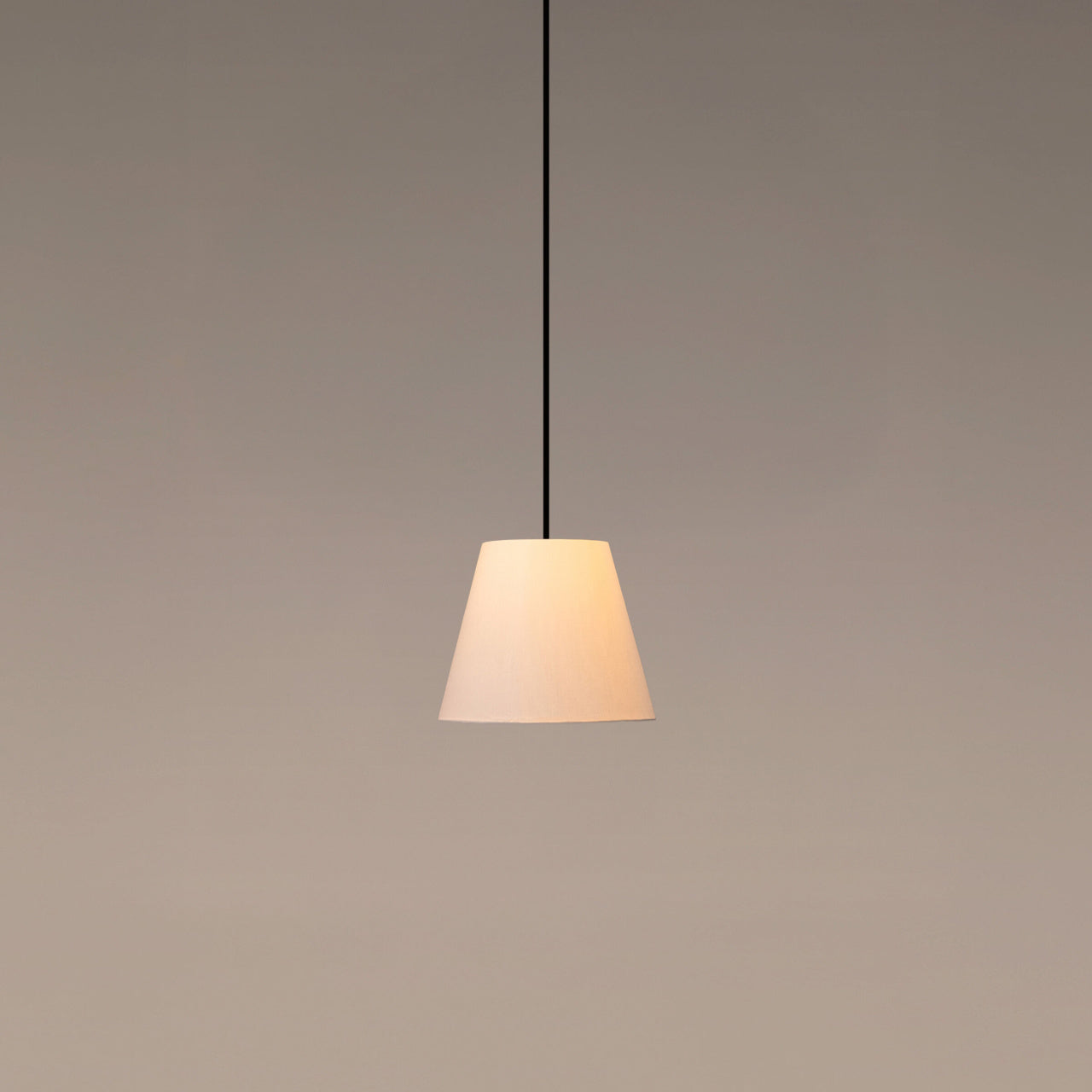 Santa & Cole MT1 pendant light with white linen shade creating soft ambient lighting in a modern interior