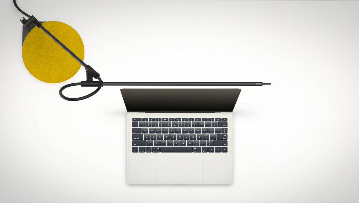 Pablo Designs Superlight table lamp in Black lighting a laptop desk, mustard felt pad