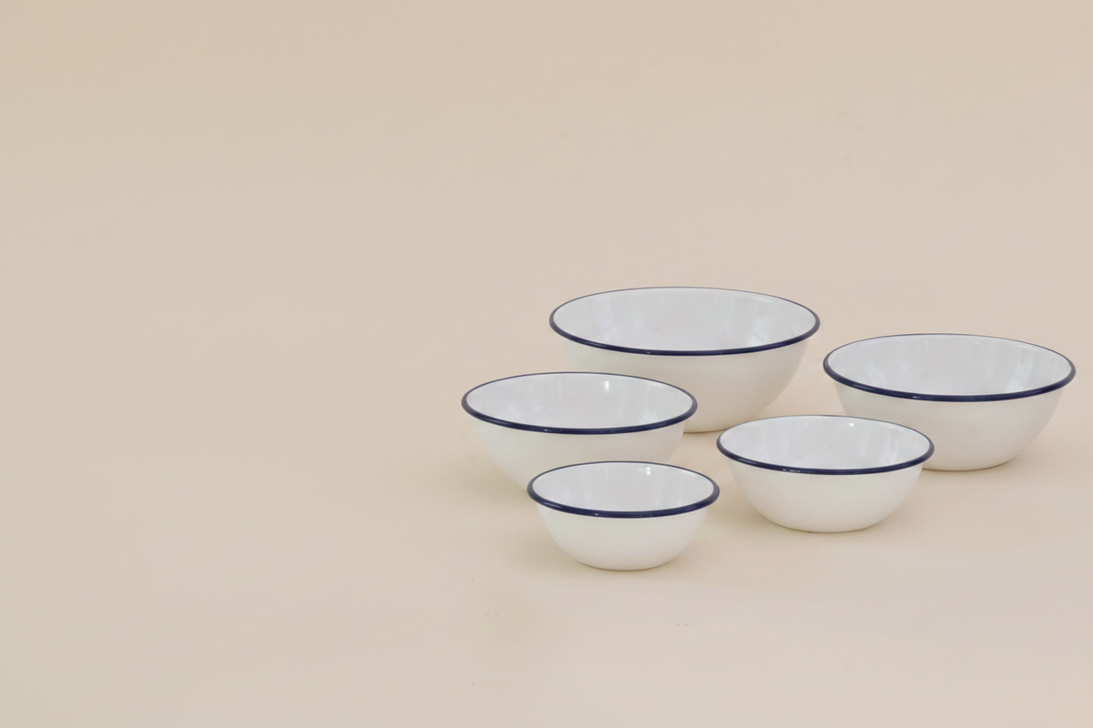 Tsukiusagi-jirushi Enamel Nesting Bowls, Set of 5, Navy Rim – set arranged on a wooden surface