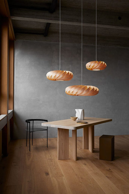 Tom Rossau TR5 pendant light – three Natural Birch pendants lit over a long table